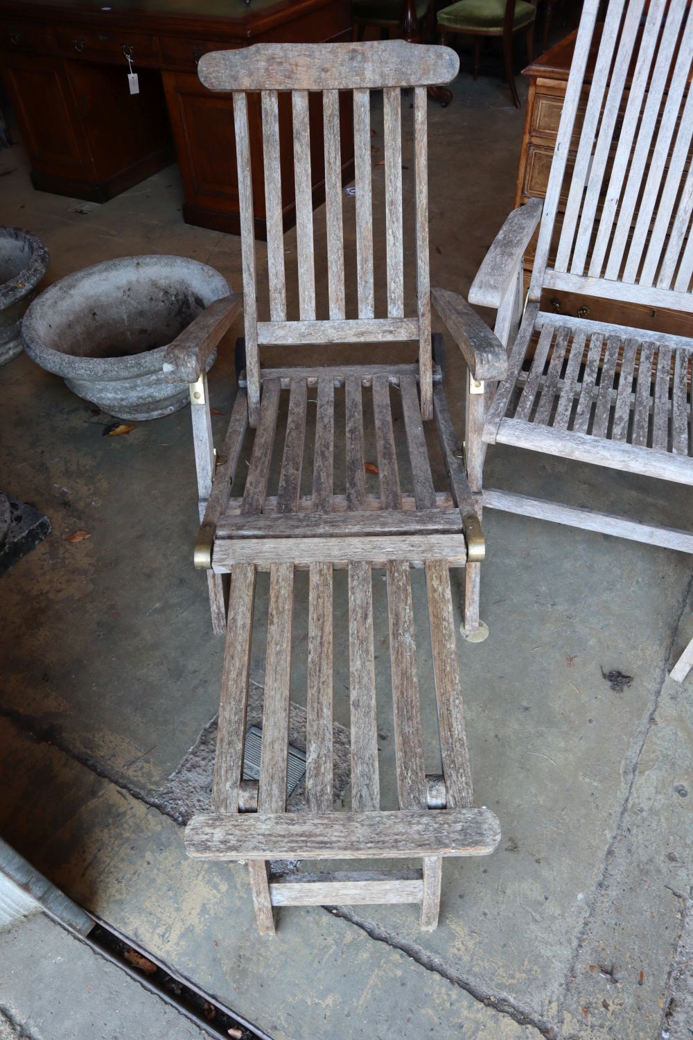 A pair of weathered teak folding garden chairs and a similar steamer chair